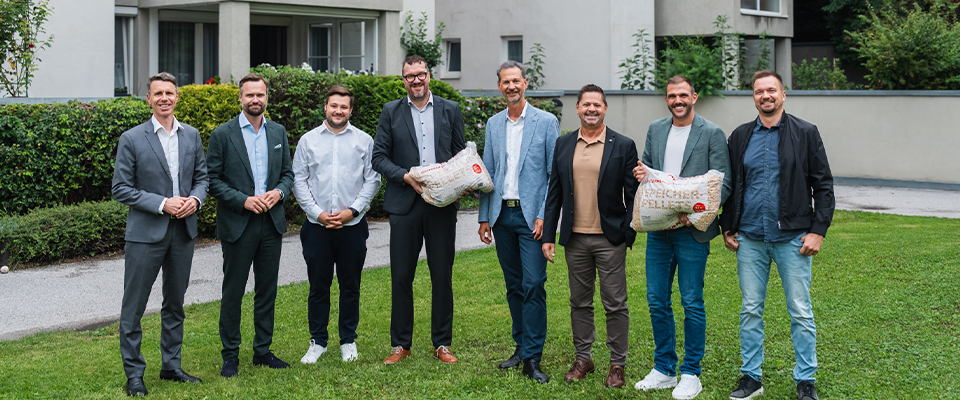 Vertreter der GUTMANN GmbH, GUTMANN Energiesysteme und TIGEWOSI vor der Wohnanlage