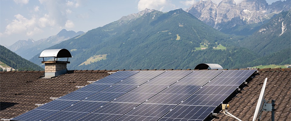 Photovoltaik-Anlage auf Dach mit Berge im Hintergrund