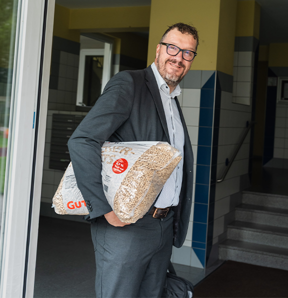Ein Mitarbeiter mit einem Pelletssack in der Hand