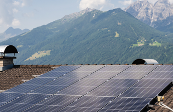 Photovoltaik-Anlage auf Dach mit Berge im Hintergrund