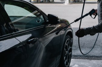 eine Person bedient eine SB-Lanzenwäsche und wäscht ein Auto