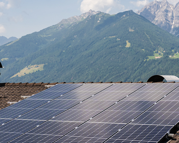 Photovoltaik Anlage auf Dach mit Bergen im Hintergrund