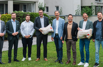 Vertreter der GUTMANN GmbH, GUTMANN Energiesysteme und TIGEWOSI vor der Wohnanlage